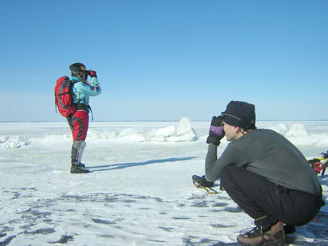 Елена наблюдает в бинокль за бегущей по льду на острова лисой.